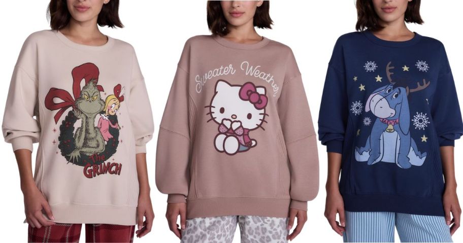 three women wearing Christmas graphic sweatshirts in the Grinch, Hello Kitty, and Eeyore