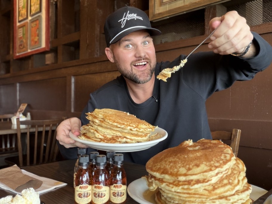 man eating stacks of pancakes on two plates at cracker barrel