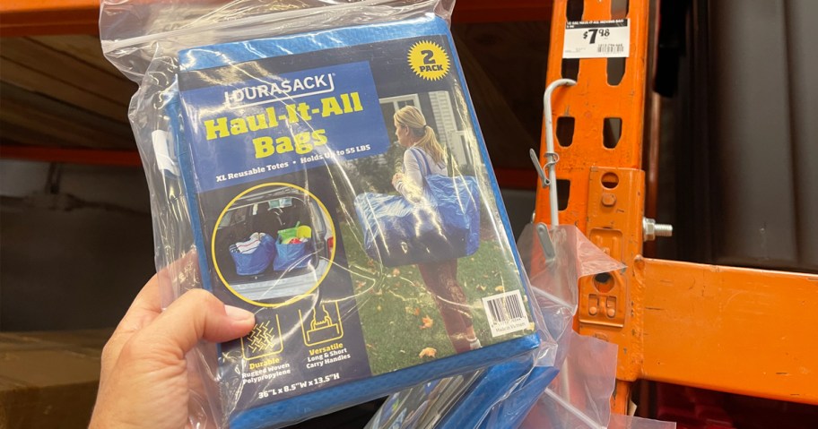 hand holding a pack of blue moving tote bags in store
