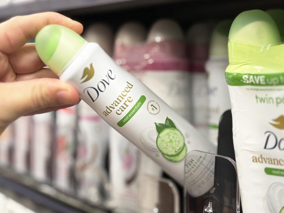 hand grabbing a bottle of dove dry spray from store shelf