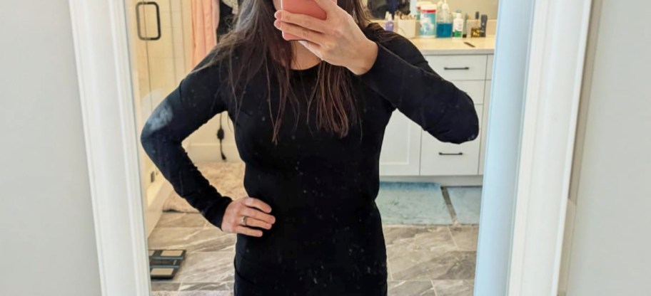 woman taking selfie in mirror wearing a black long sleeve top