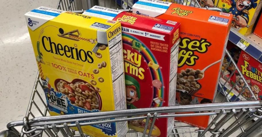 3 boxes of general Mills cereal in a shopping cart