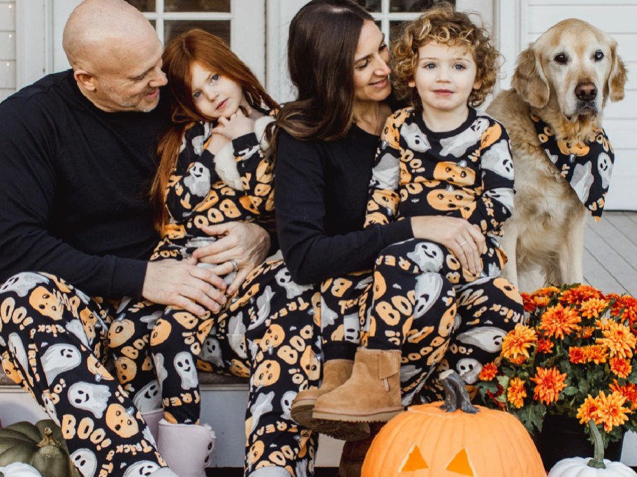 family of 4 wearing matching halloween pajamas