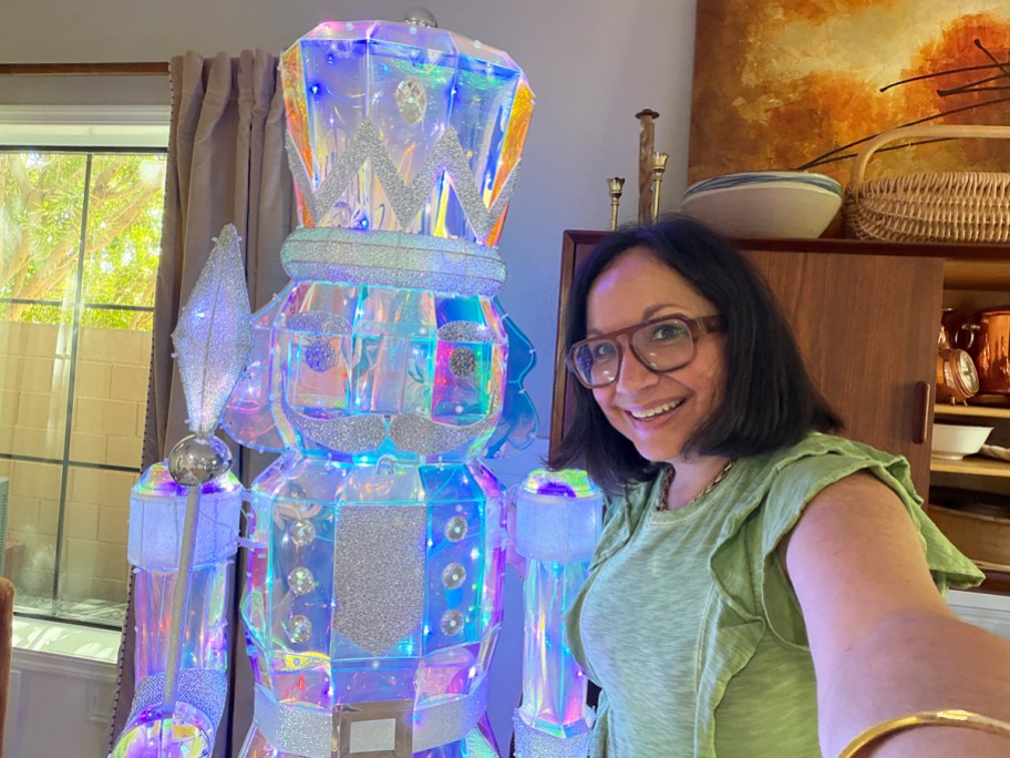 woman taking a selfie with an iridescent nutcracker decoration