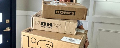 Woman holding a huge stack of Kohl's Boxes
