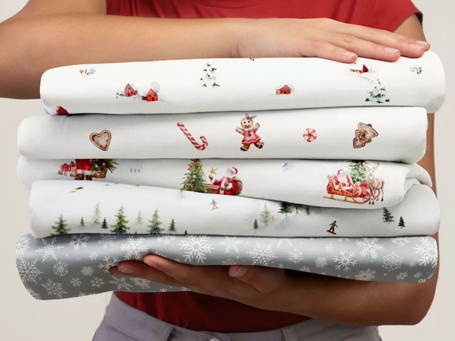 woman holding a stack of holiday sheets