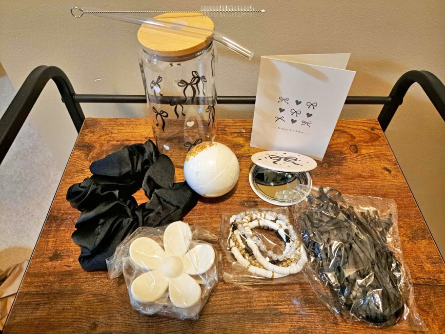 black and white tumbler, scrunchie, bracelets, bath bomb, mirror, and card