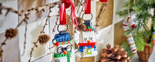 LEGO Snowman Ornaments hanging from a branch by red ribbons