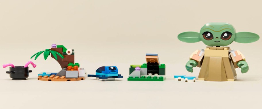 A LEGO Star Wars Grogu build set featuring a large buildable Grogu figure alongside small landscape builds, a cooking pot, and a creature.