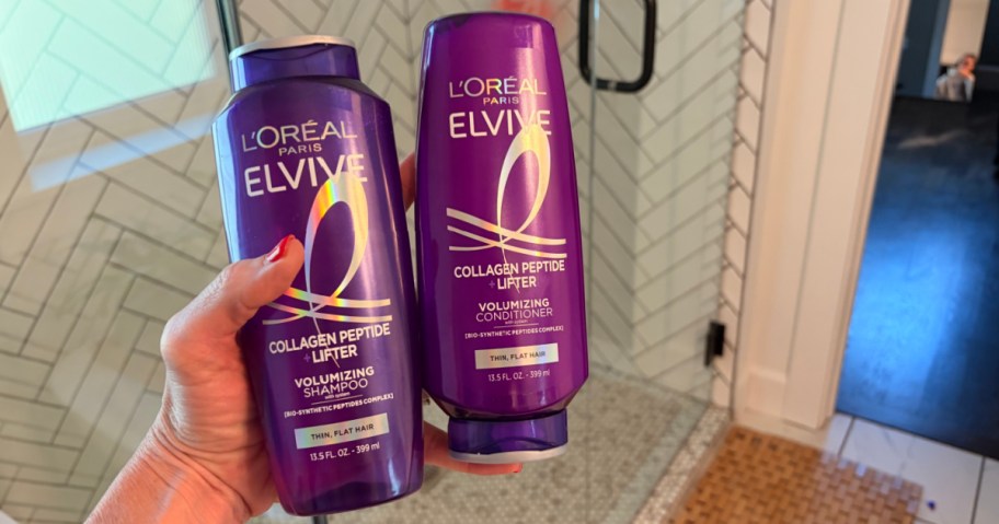 Woman holding shampoo and conditioner of L'Oreal Paris Elvive collagen, peptide lifter