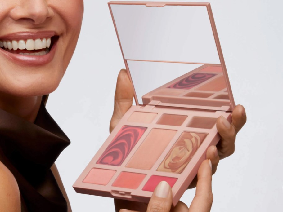 woman holding up Laura Geller Hydrating Cream Color + Glow Palette
