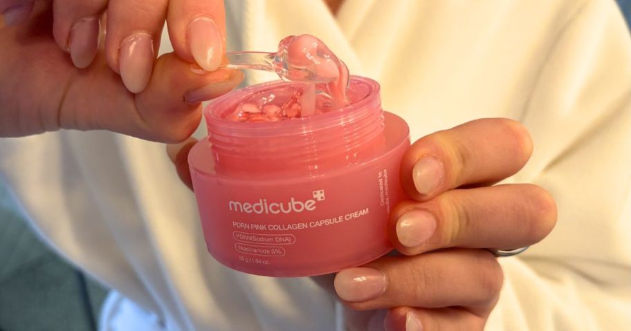 Woman scooping Medicube Capsule Collegen Cream from a jar