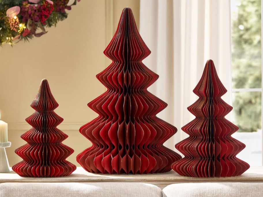 3 red honeycomb paper trees on a table