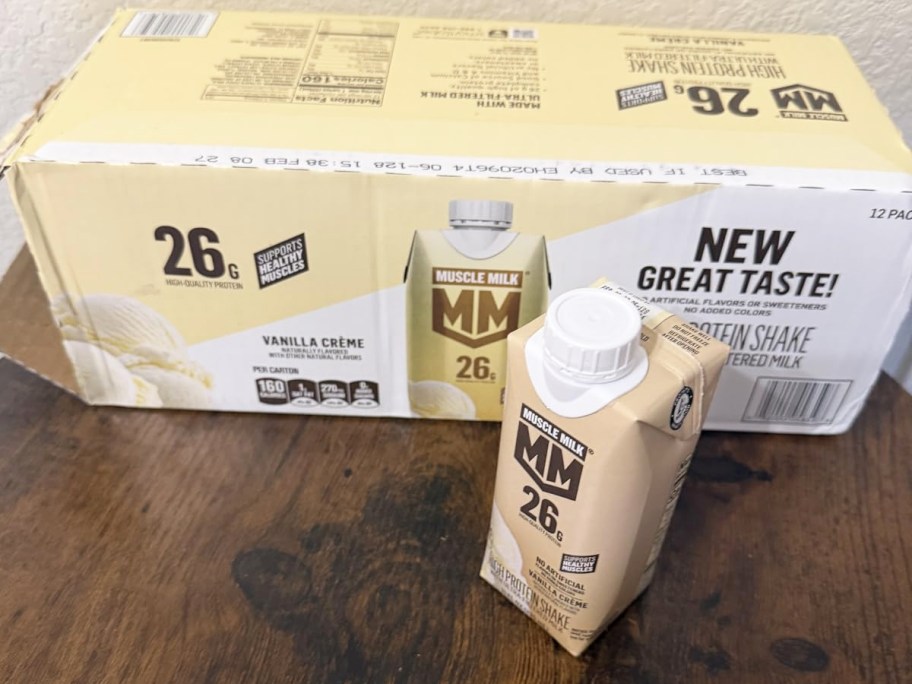 box and carton of Muscle Milk High Protein Shakes on a wood table