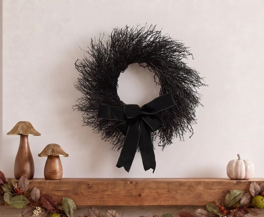 a black wreath over a fireplace mantle