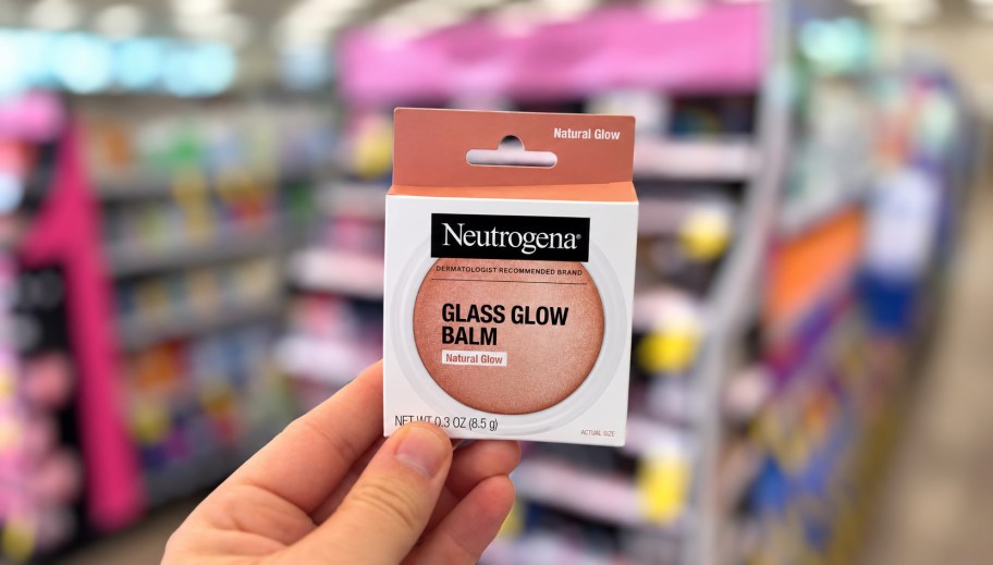 hand holding up a makeup item in a store aisle