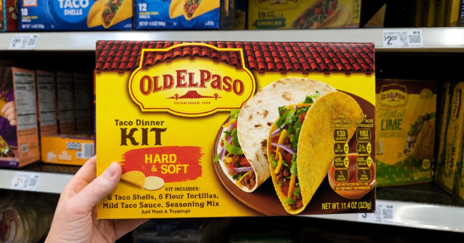 hand holding up Old El Paso Hard & Soft Taco Dinner Kit box in store aisle