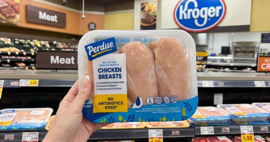 Hand holding up a apackage of Perdue Chicken