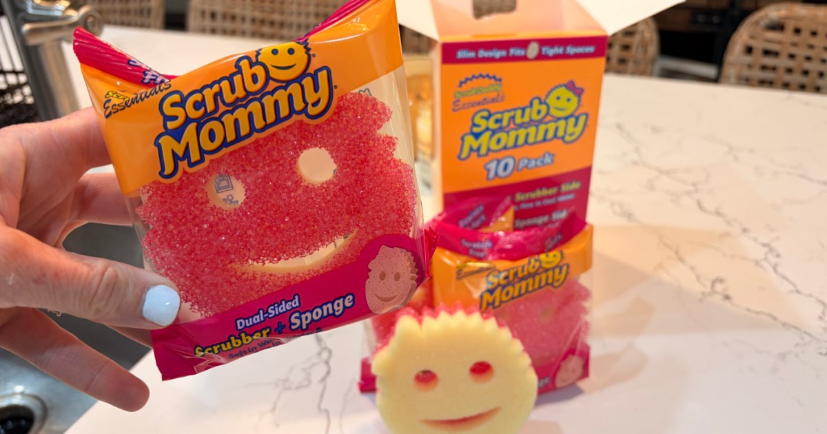 Hand holding scrub mommy pack in front of box on kitchen countertop