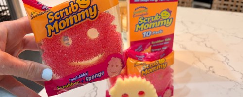 Hand holding scrub mommy pack in front of box on kitchen countertop