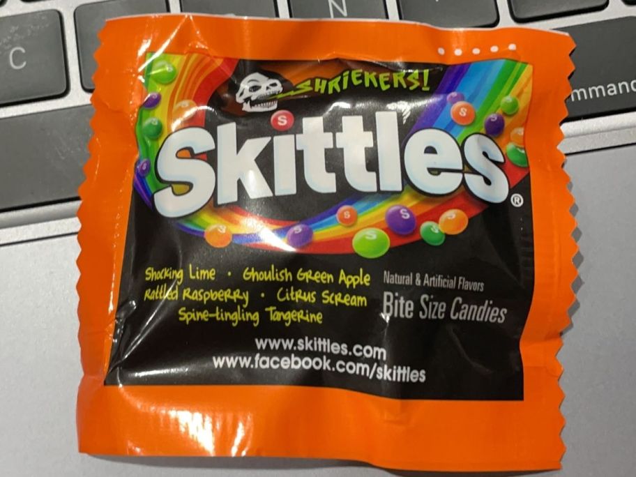 Skittles sour fun size on top of a laptop