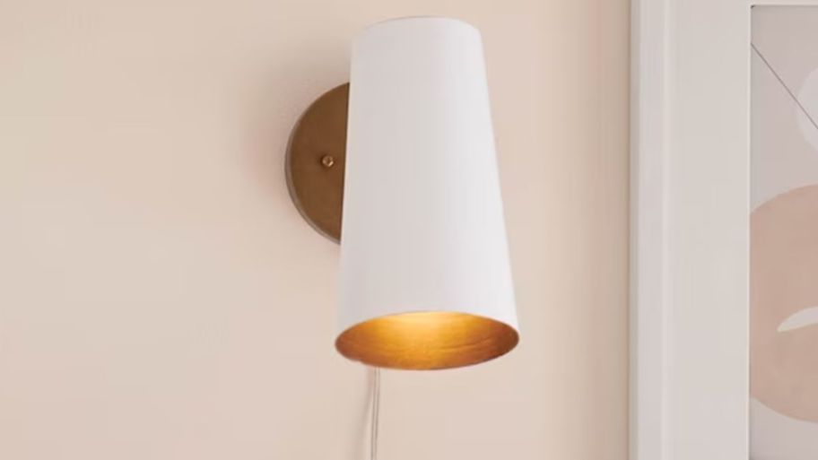 White long wall sconce displayed on a beige wall