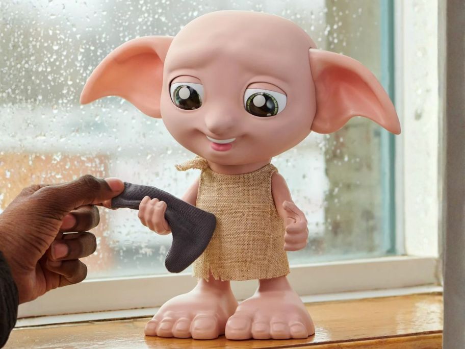 hand touching Wizarding World Harry Potter Interactive Magical Dobby Elf Doll