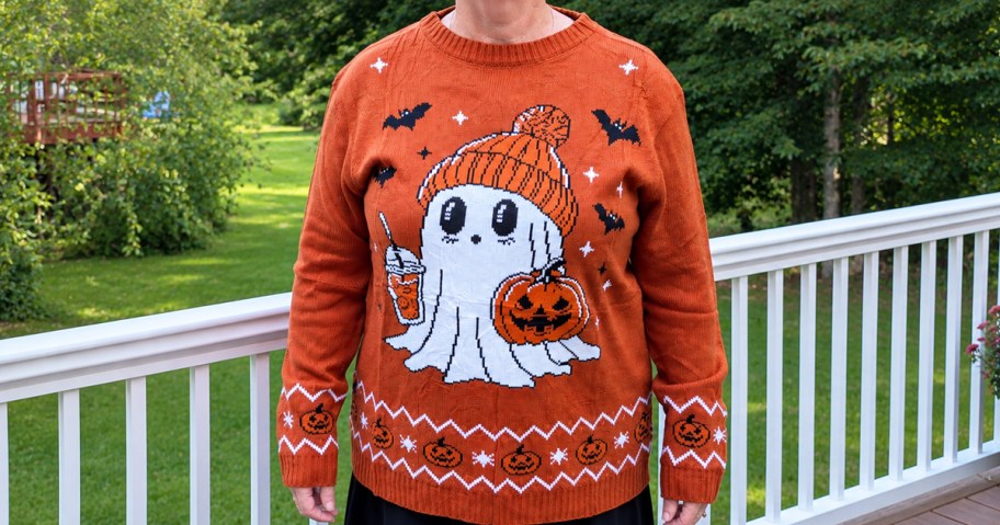 woman wearing an orange sweater with a ghost on it