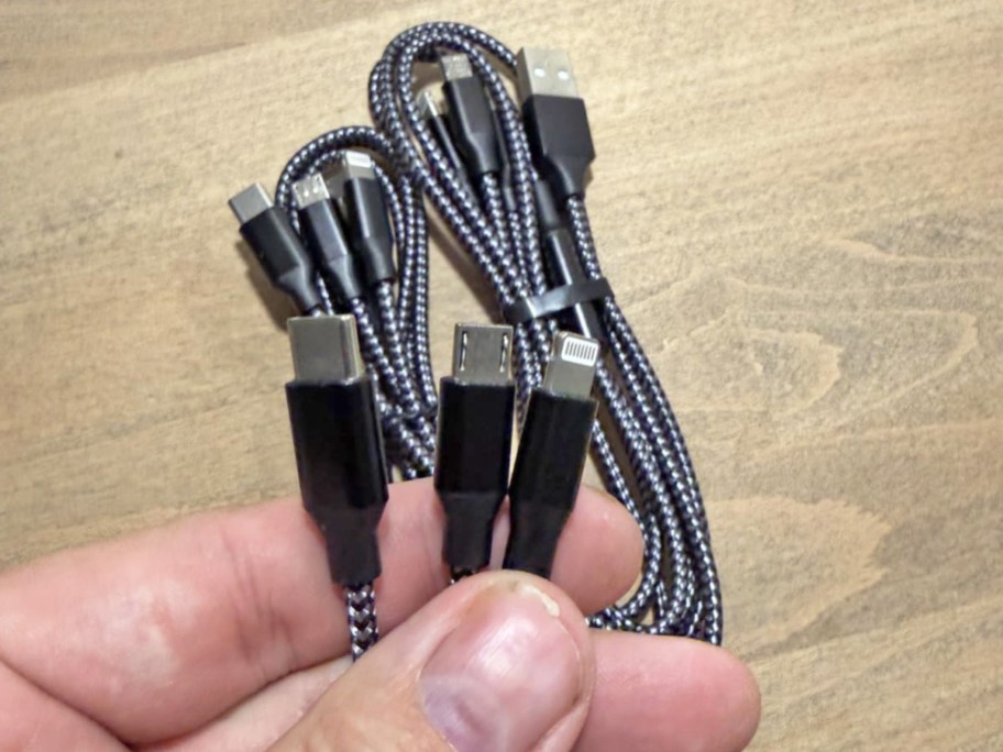 hand holding black multi-charging cable