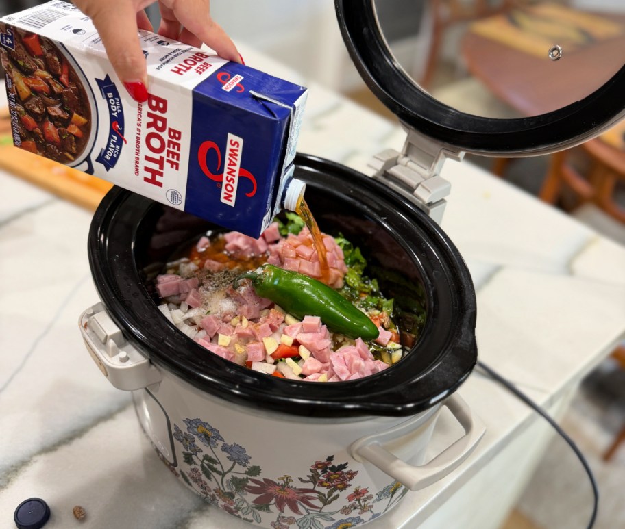 adding swanson broth to slow cooker with dried beans 