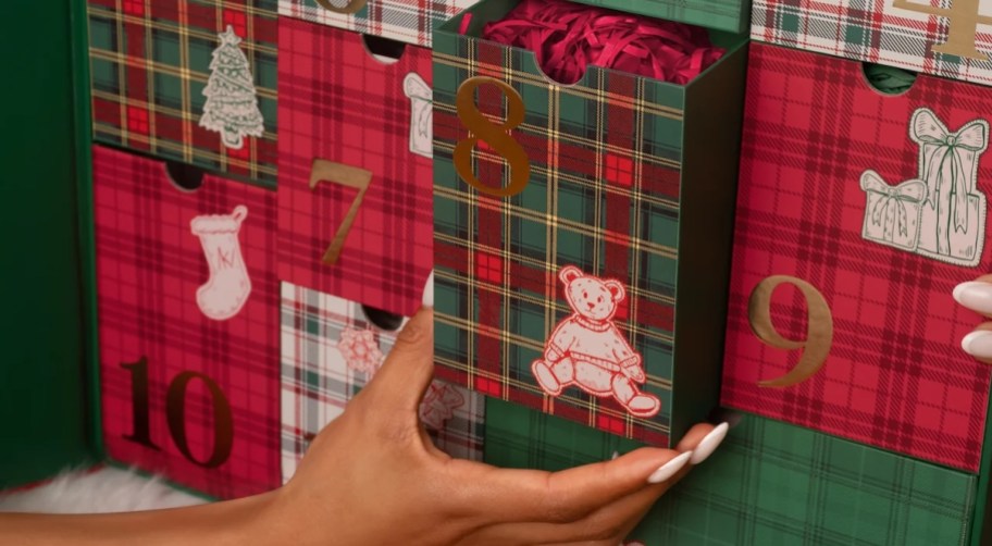 hand pulling out number 8 box from advent calendar