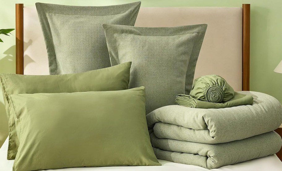 green comforter, sheets, and pillows 