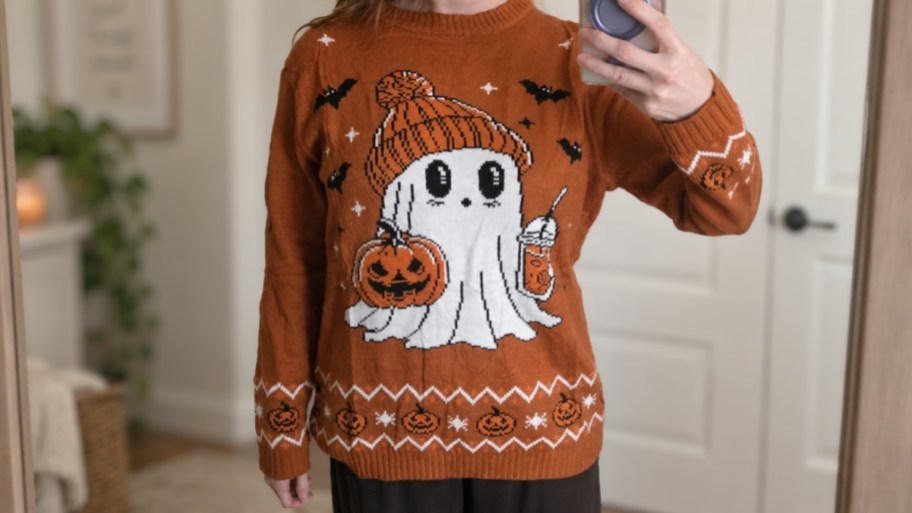 woman taking a selfie in a halloween sweater