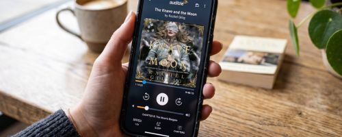 hand holding smartphone with audible app on it