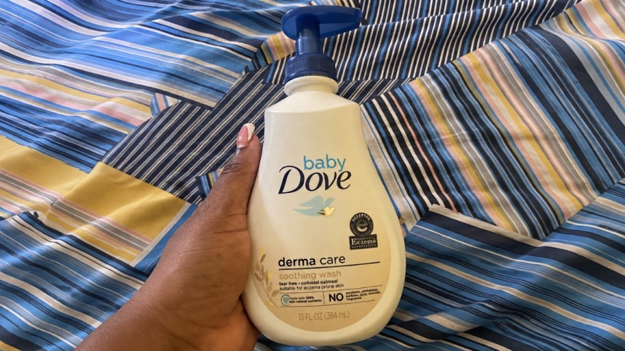 a hand holding a bottle of dove baby wash