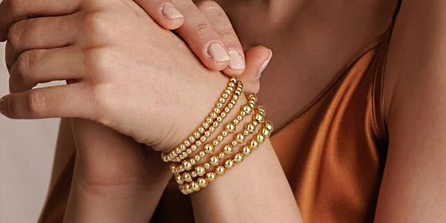 women wearing 5 gold bracelets 