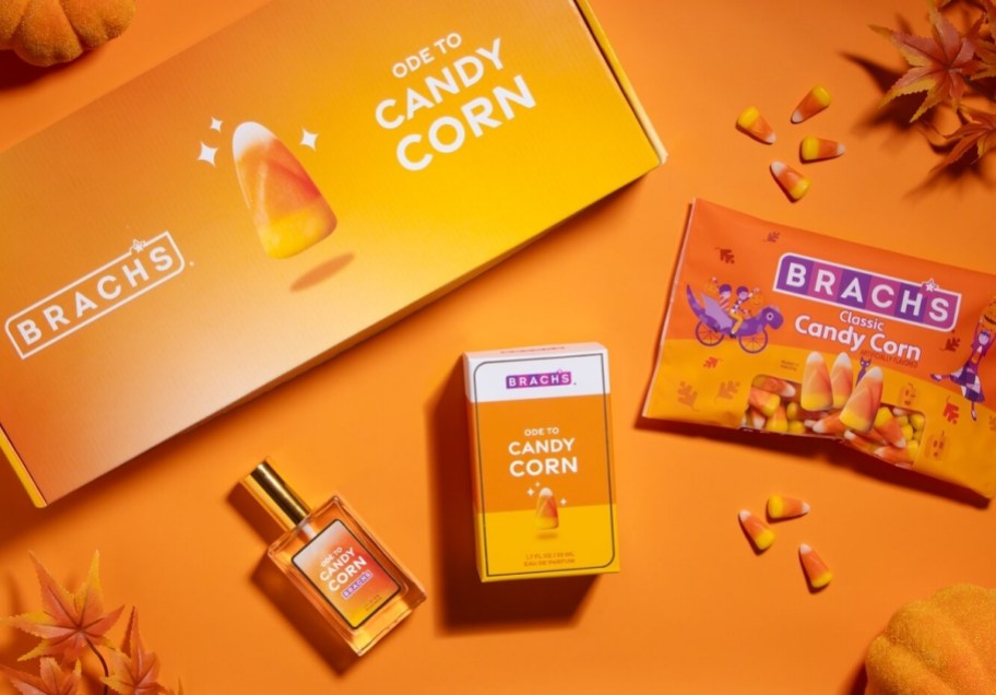 a bottle of candy corn perfume with a bag of candy corn