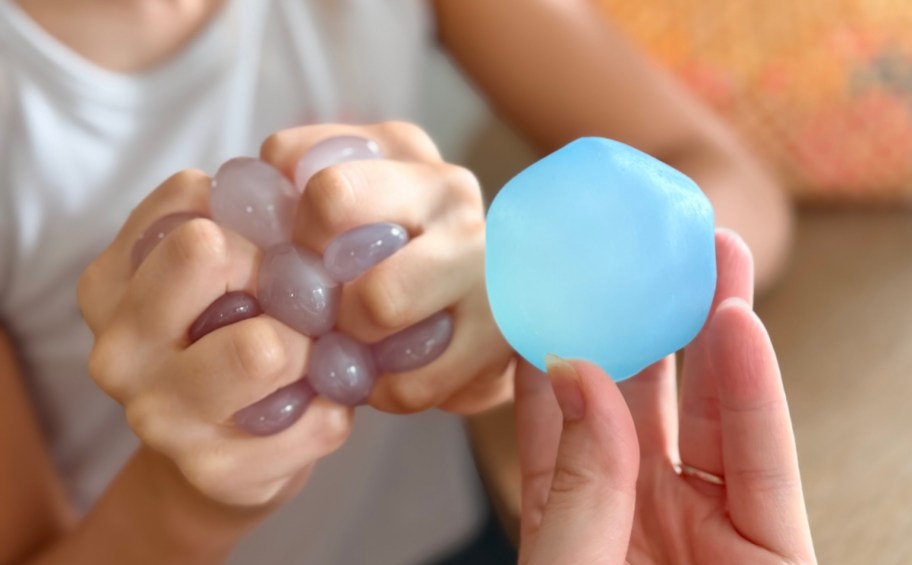 hands squeezing coconut oil ball and holding blue circle