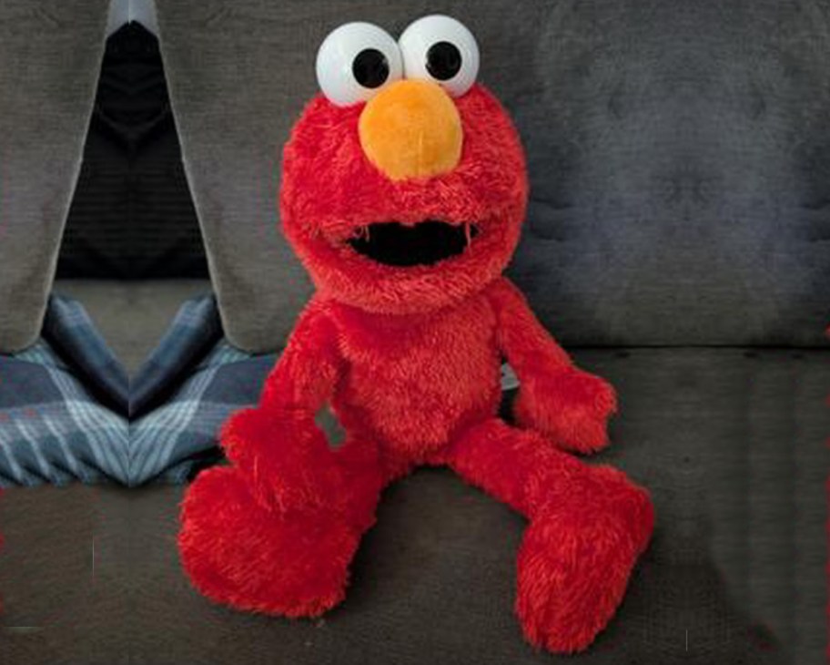 elmo doll on grey couch