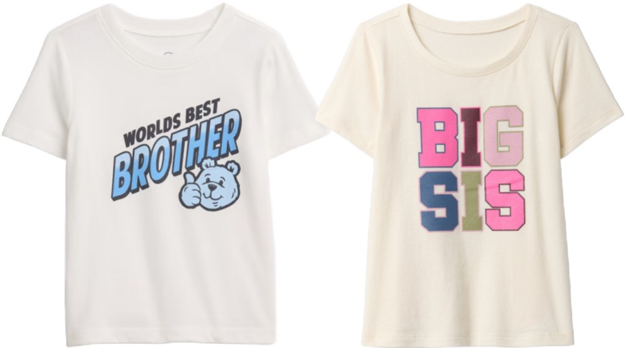 Two off-white children's t-shirts, one featuring a "Worlds Best Brother" graphic with a cartoon bear and the other with a colorful "Big Sis" block text design.
