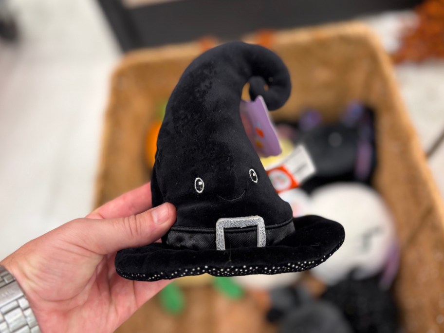 holding a plush witch hat