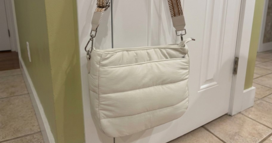 white purse hanging on a door