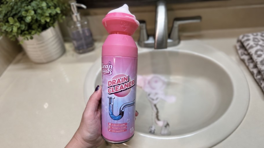 a hand holding a can of Yougou drain cleaning foam