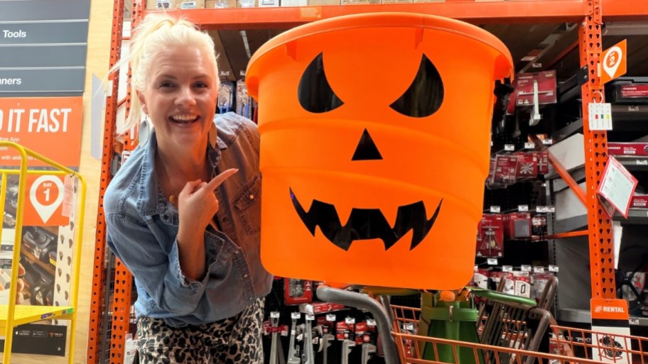 woman with a huge orange jack o lantern bucket