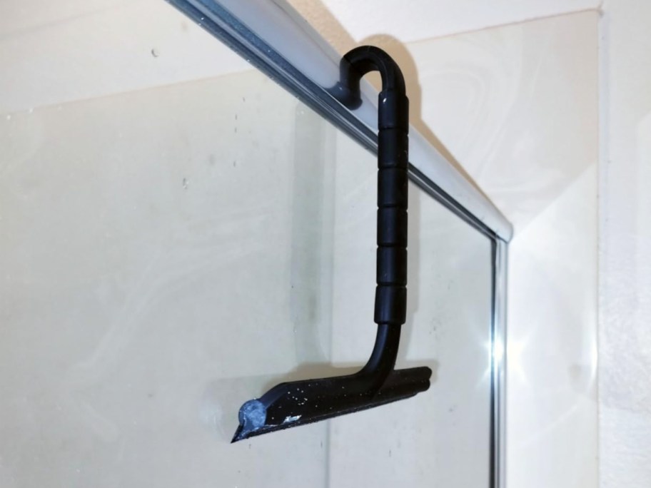 black squeegee hanging over shower door
