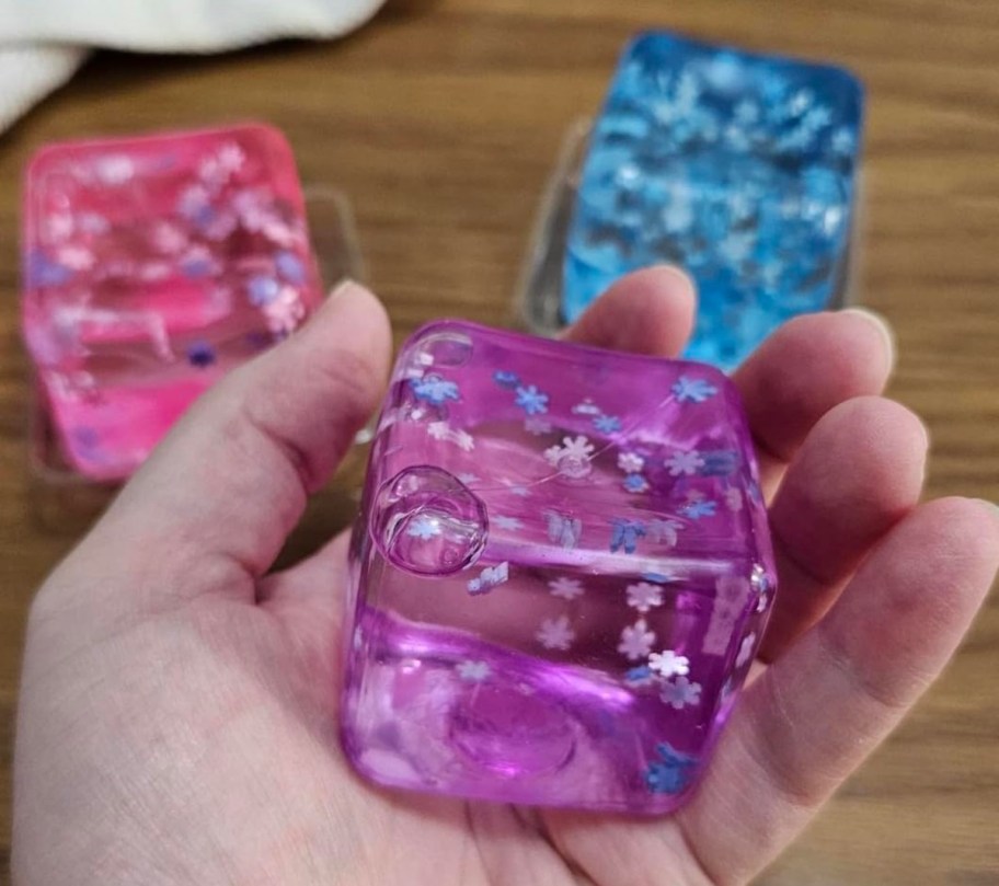 hand holding purple cube squishy