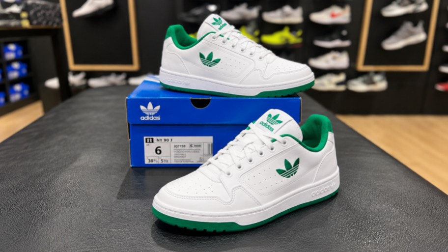 a pair of green and white kids adidas shoes
