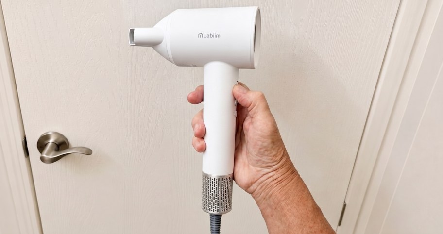 hand holding up a white hair dryer