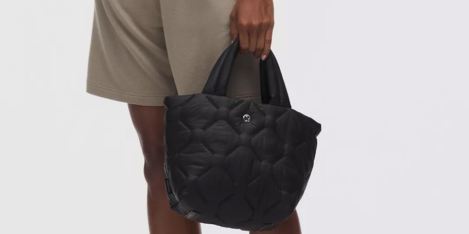woman holding black tote 