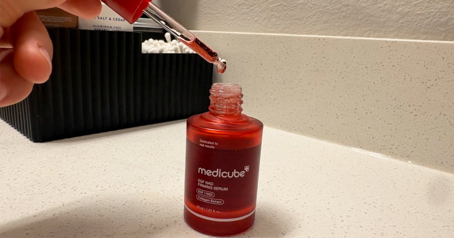 taking dropped out of red bottle of medicube NAD EGF Firming Serum